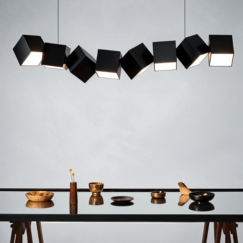 Clérachic eight black aluminium cubes lit from below above a glass-topped trestle table set with wooden and brass bowls.
