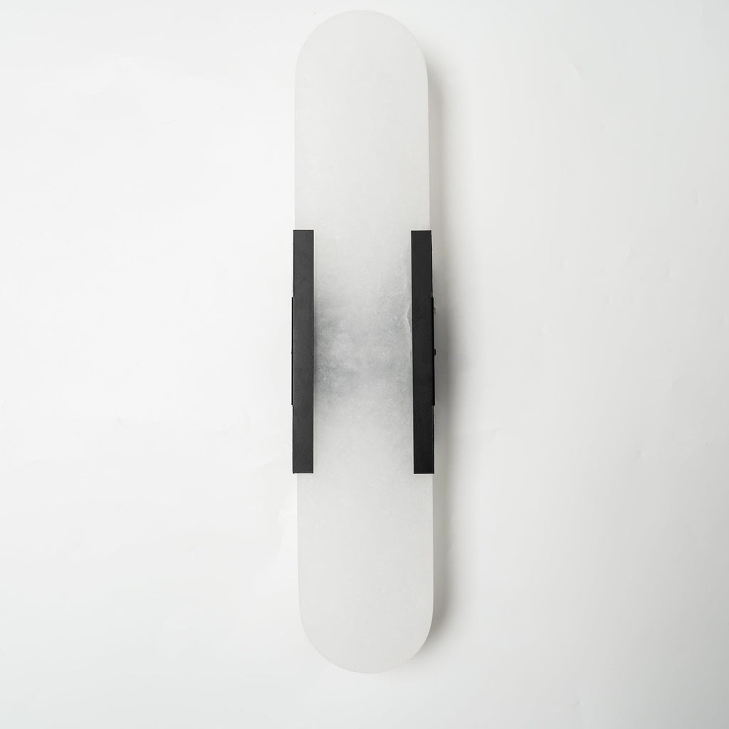 The Clérachic sconce unlit with black bars, the grey veining of the alabaster clear against a white wall