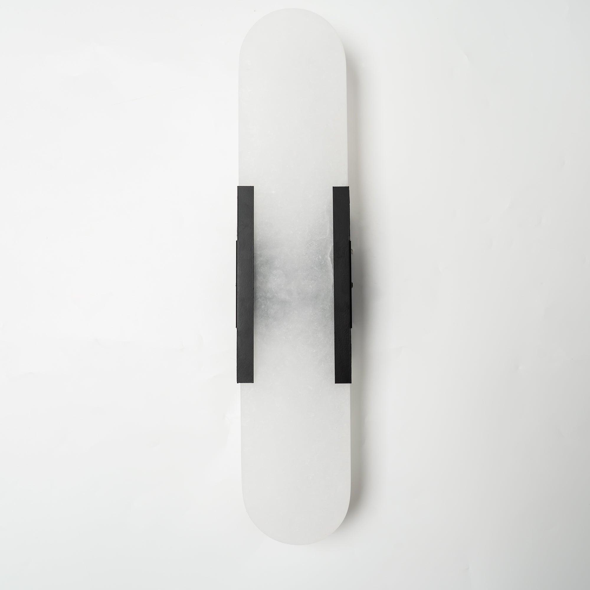 The Clérachic sconce unlit with black bars, the grey veining of the alabaster clear against a white wall