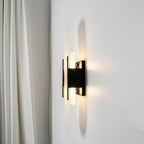 Clérachic sconce lit at an angle beside a cream curtain, light washing up and down the alabaster