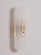 The Clérachic sconce in brass, unlit on a soft lilac-grey backdrop with the bars set low on the panel