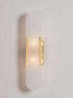 Clérachic sconce dimly lit in brass on pale grey, the stone showing its natural cloudy banding