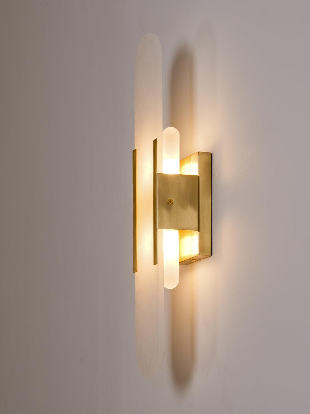 Clérachic sconce lit and turned three-quarters right, showing the depth of the brass mount