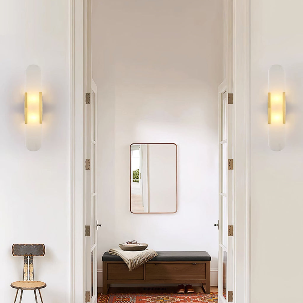 Clérachic sconces mounted either side of a doorway leading to a bench, mirror and red patterned rug