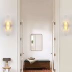 Clérachic sconces mounted either side of a doorway leading to a bench, mirror and red patterned rug