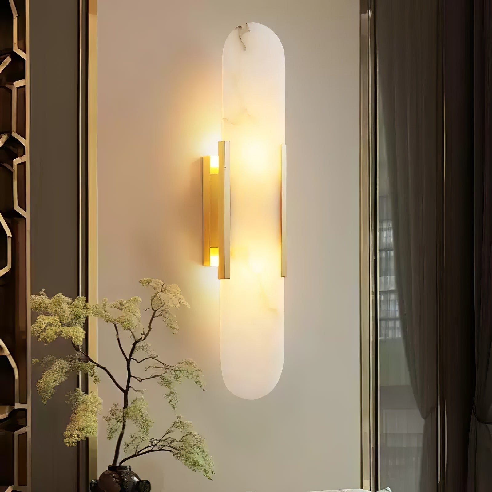 The Clérachic sconce lit beside a gold fretwork screen with a maple branch arranged in front