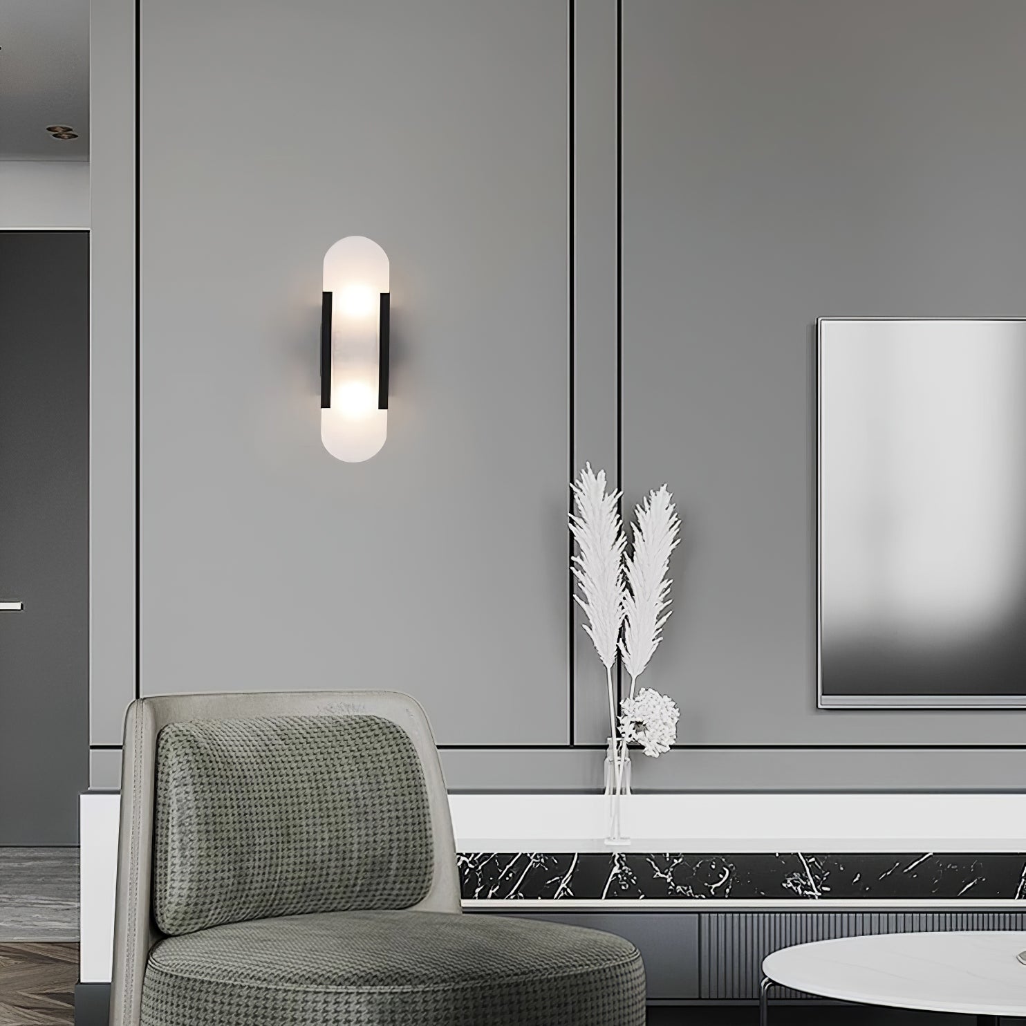 The Clérachic sconce with black bars lit on a grey panelled wall above a green chair and marble ledge