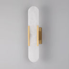 The Clérachic sconce unlit head-on in brass, the hardware sitting low on the tall stone capsule