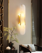 Clérachic sconce lit beside a gold screen and a bonsai, curtains drawn across the window behind