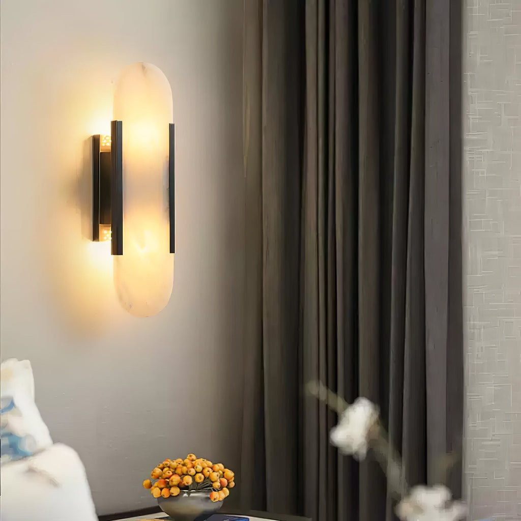 Clérachic sconce lit on a pale wall next to heavy grey curtains, a bowl of orange berries beneath