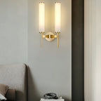 Clérachic Olrinyra twin in brass lit above an upholstered headboard, throwing a warm column up the wall.
