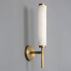 Clérachic Olrinyra in brass unlit on grey, the stone's cool white and pale veining clear against the metal.