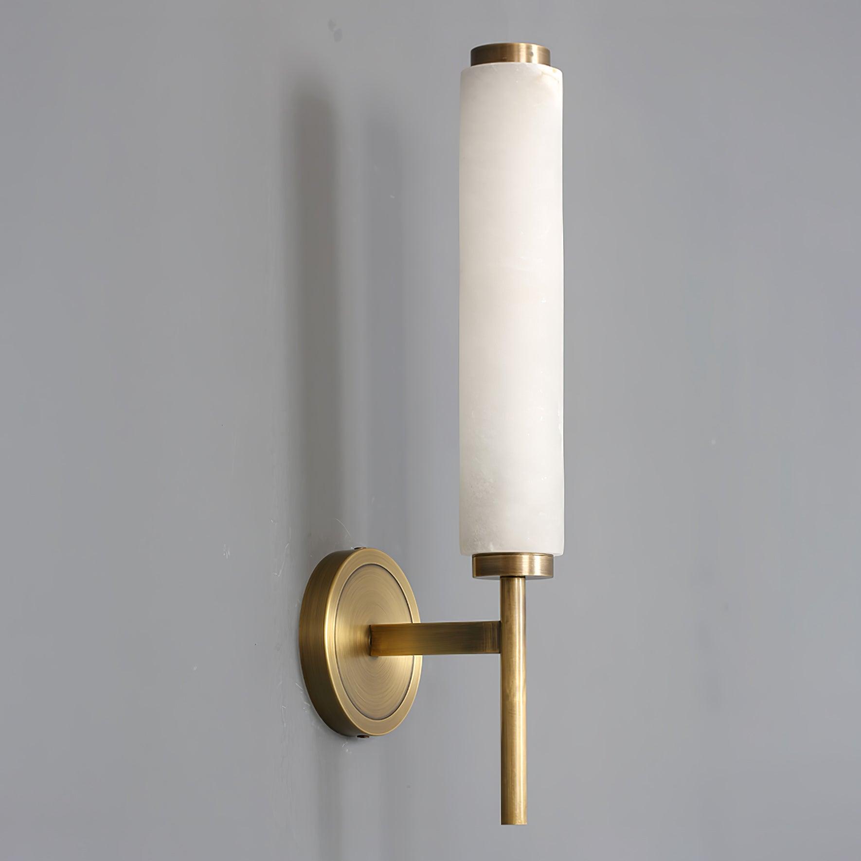 Clérachic Olrinyra in brass unlit on grey, the stone's cool white and pale veining clear against the metal.