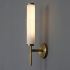 Clérachic Olrinyra in brass lit at three-quarter view, arm and tapered tail reading against a grey wall.
