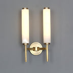 Clérachic Olrinyra twin in brass with the tubes spaced wide, both lit above the shared brass wall mount.