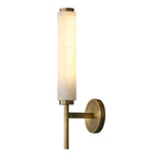 The Clérachic Olrinyra in brass on white, lit and angled so the depth of the wall bracket is visible.