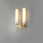 Clérachic Olrinyra twin in brass, cropped tight on the two lit stone cylinders and their brass collars.