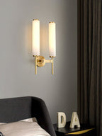 Clérachic Olrinyra twin in brass lit above a bed, beside a nightstand dressed with sculptural letter decor.