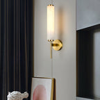 The Clérachic Olrinyra in brass lit near a dark drape, above a leaning artwork and a white plaster bust.