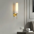 The Clérachic Olrinyra in brass lit beside a wall socket, above a nightstand holding a vase and books.