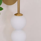 Close view of the brass arm and cone fitting where it meets the top opal ball on this Clérachic wall light.