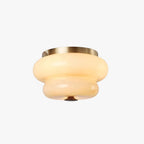 Tiered Clérachic flush-mount light with a cream opal glass shade, a brass-toned ceiling ring and a dark finial, on a white backdrop.