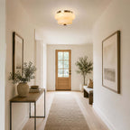 Looking down a hallway with a long runner, a Clérachic flush-mount light lights the ceiling in front of a wooden door.