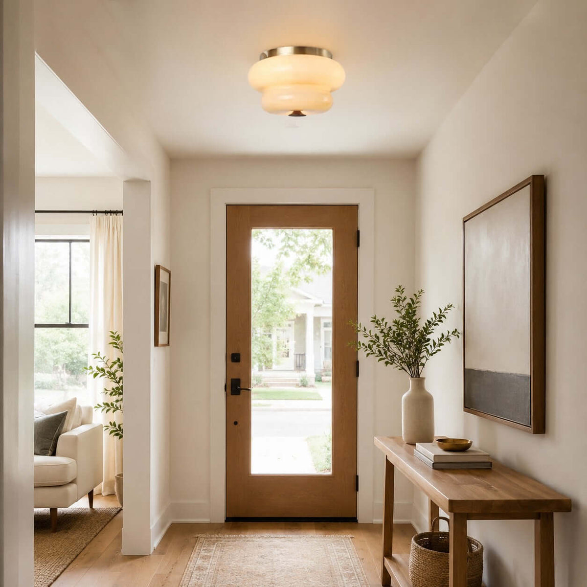 A Clérachic flush-mount light above an entrance hall with a glazed wooden door and a large abstract painting.