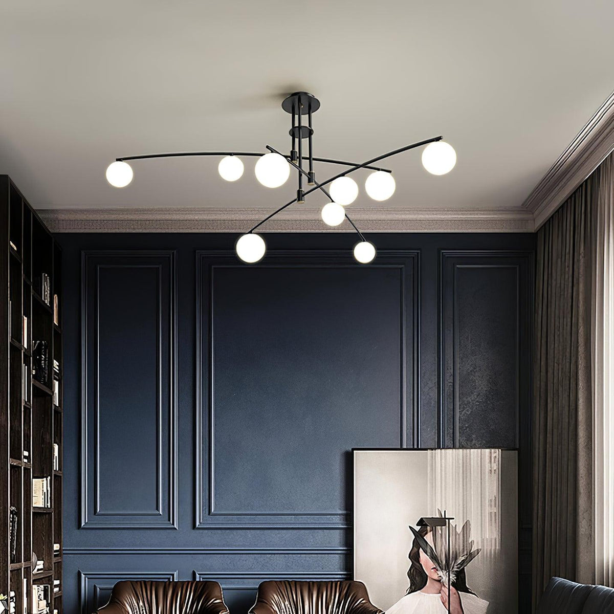 A black Clérachic globe chandelier above a navy panelled room, with brown leather chairs and a framed artwork below.