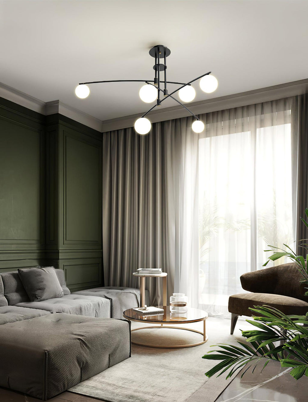 A black Clérachic chandelier in a living room with olive-green panelling, grey curtains and a deep low sofa.