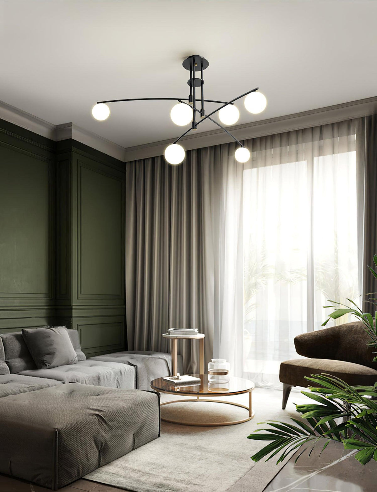 A black Clérachic chandelier in a living room with olive-green panelling, grey curtains and a deep low sofa.