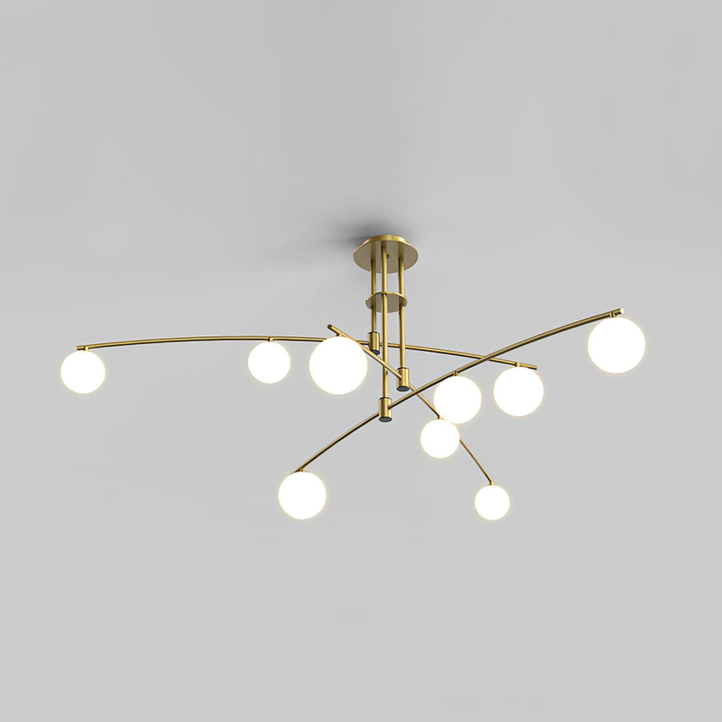 Gold Clérachic chandelier with nine opal globes on curved arms, lit, shown on a plain grey backdrop.