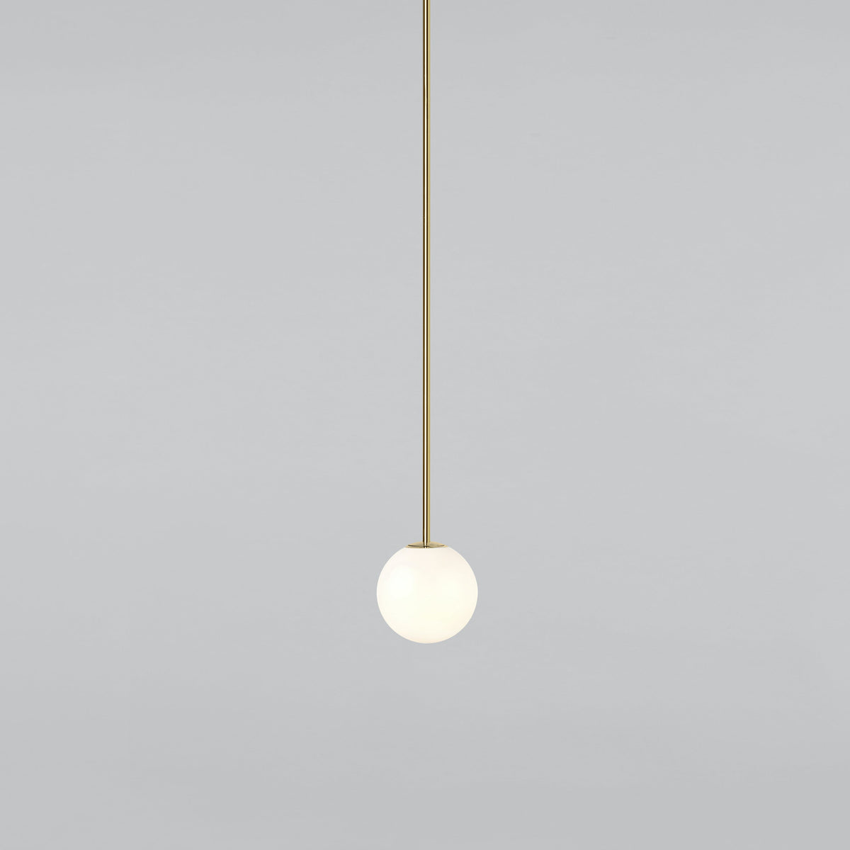 Small opal sphere on a long brass rod, this Clérachic pendant on a light grey backdrop.