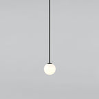 Small opal sphere on a long black rod with a black cap, this Clérachic pendant on a light grey backdrop.