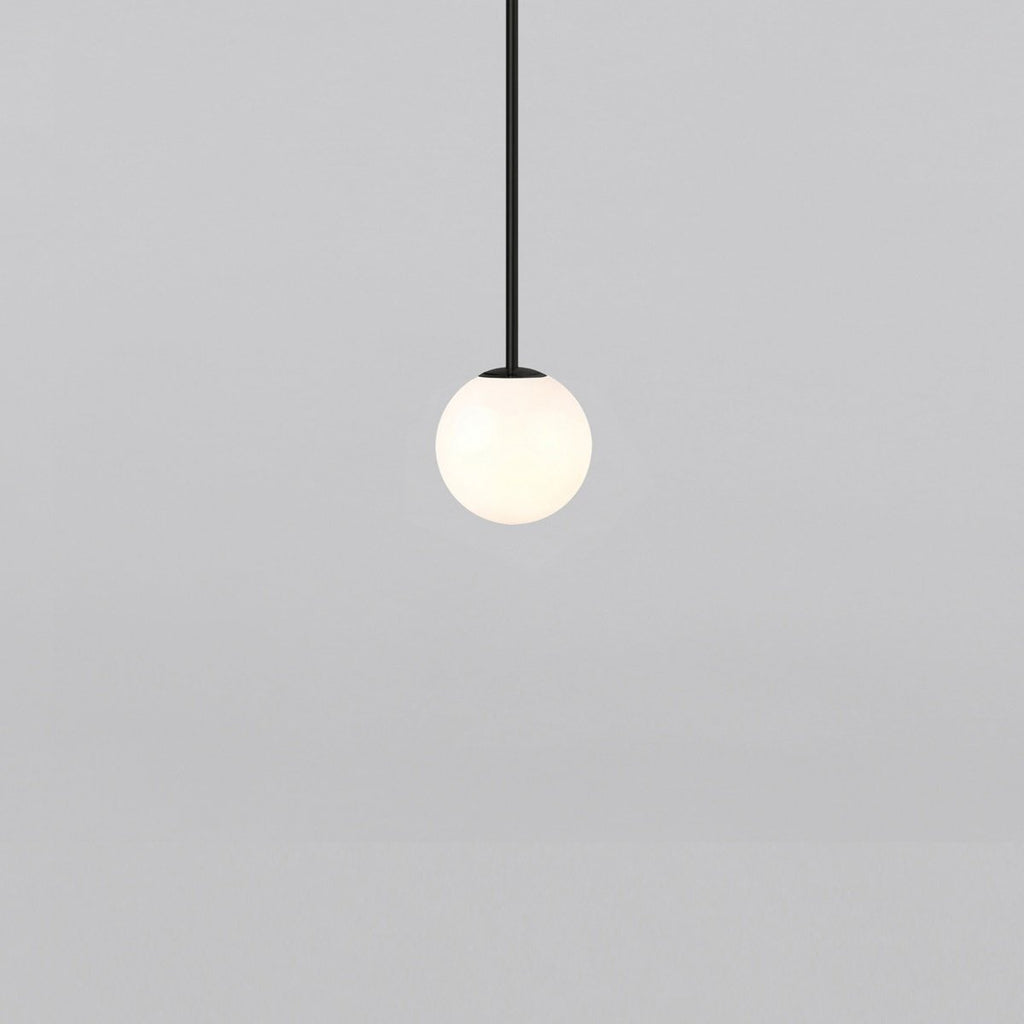 Opal sphere on a short black rod, this Clérachic pendant on a light grey backdrop.