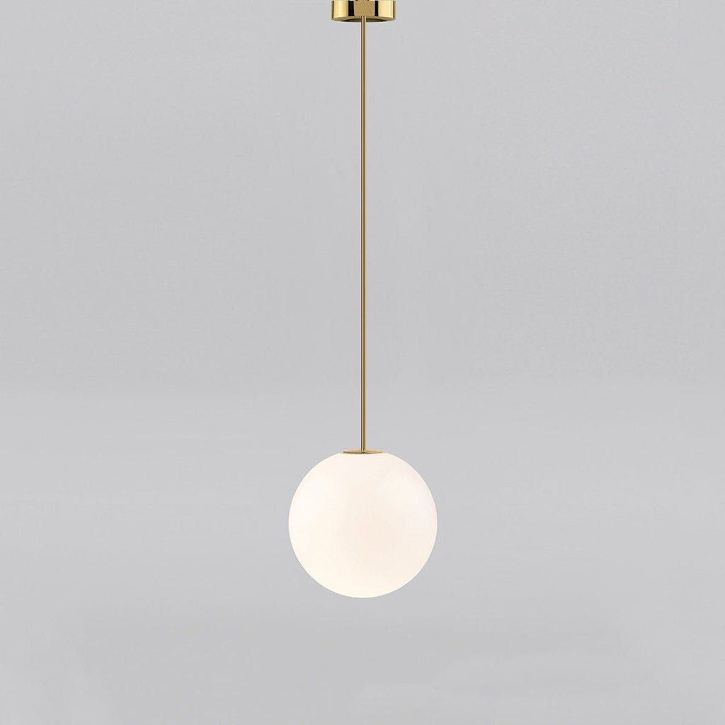 Medium opal sphere on a brass rod with a brass cap at the ceiling, this Clérachic pendant on a light grey backdrop.