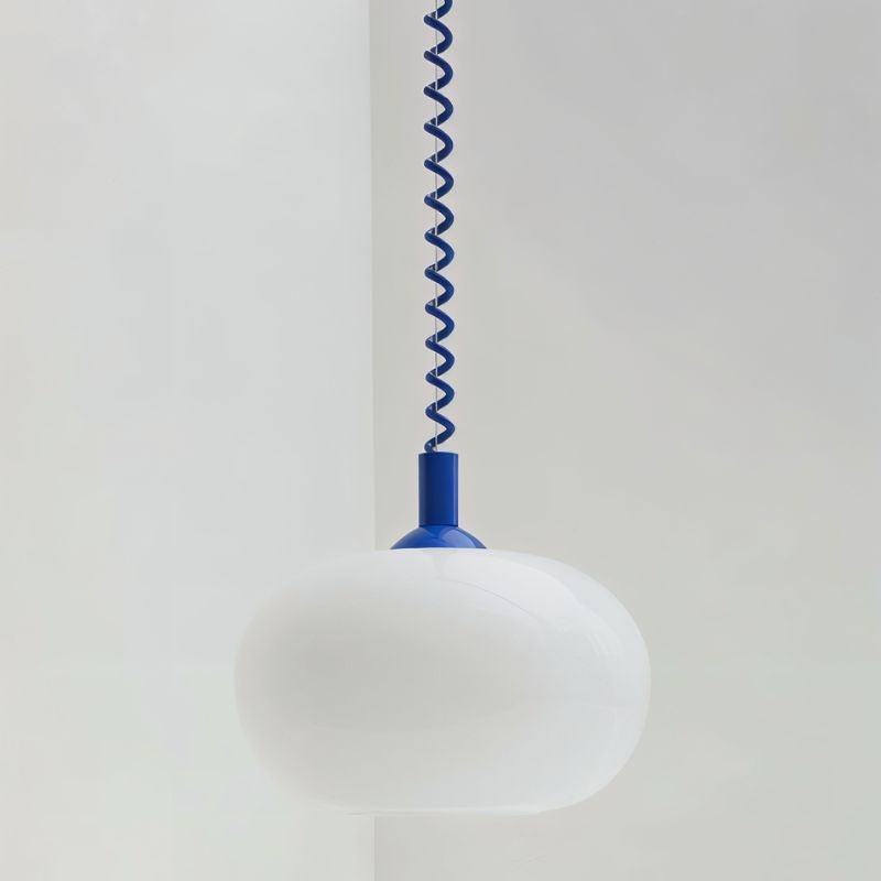 Close view of a Clérachic white opal glass pendant shade with a cobalt blue coiled spring cable and rounded cap.