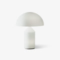 This Clérachic table lamp on a plain white backdrop, a milk-white glass dome shade over a smooth cone-topped cylinder base.