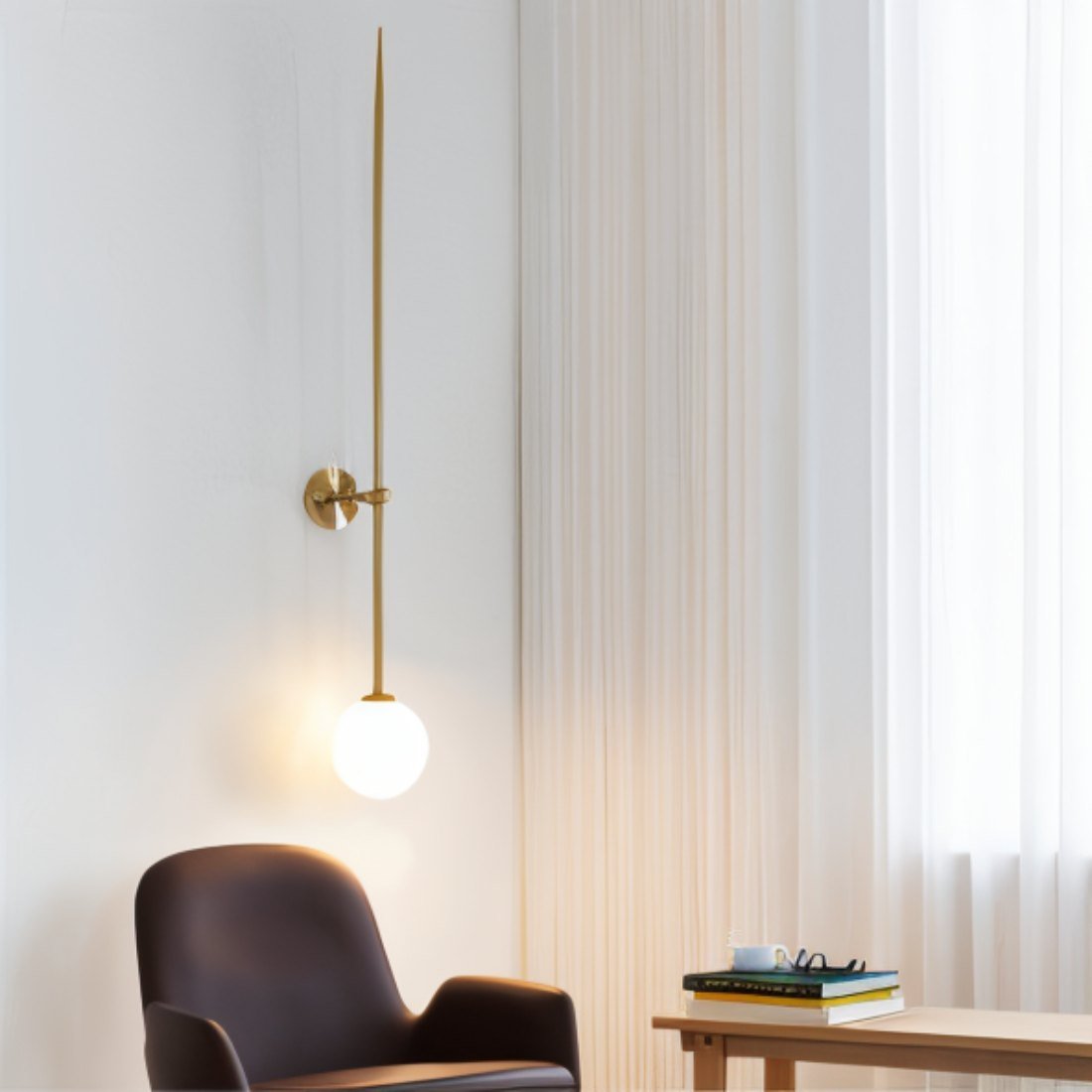 Clérachic gold wall light with a tall slim rod and a glowing opal globe beside an armchair and sheer curtains.