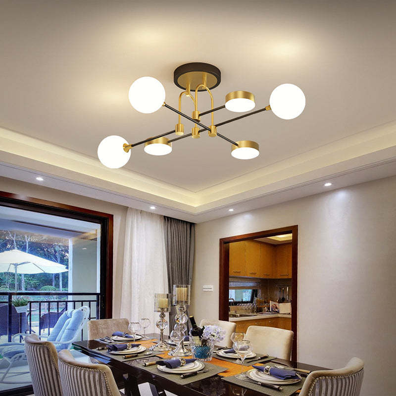 The Clérachic Opal Globe Ceiling Light in its 6-light crossed-arm layout, mounted semi-flush above a dining table with a balcony view beyond.