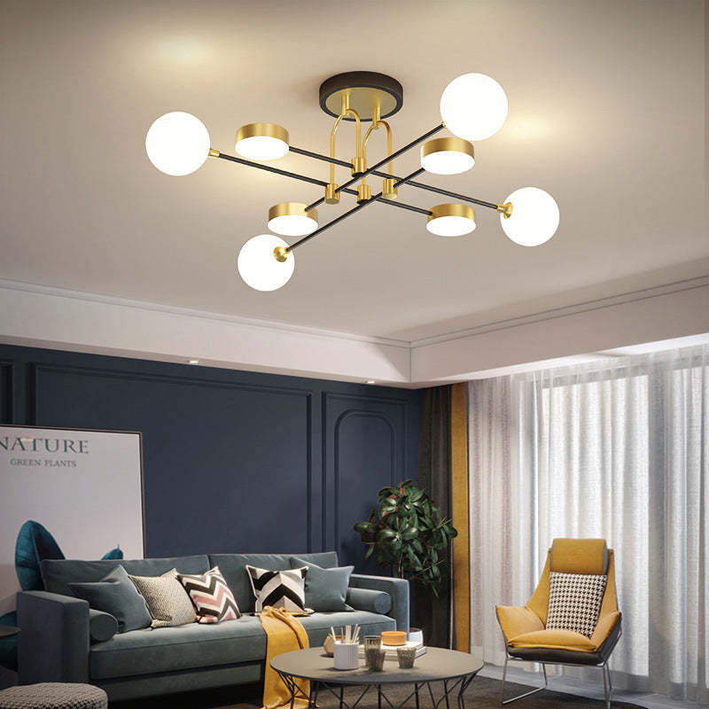 The Clérachic Opal Globe Ceiling Light in a living room with navy paneled walls, its opal globes and gold discs glowing warm white.