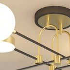Close-up of the Clérachic Opal Globe Ceiling Light's matte-black ceiling canopy and arched brushed-gold stems feeding its crossed arms.