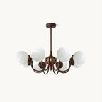 Eight-light Clérachic chandelier with white glass globes on curved antique bronze arms and a short rod, on a plain white backdrop.