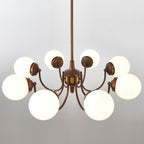 Underside view of the eight-light Clérachic chandelier, showing white globes on antique bronze arms with a brass band at the centre.