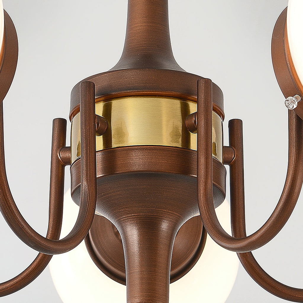 Close view of the brass band and curved bronze arms at the hub of this Clérachic chandelier.