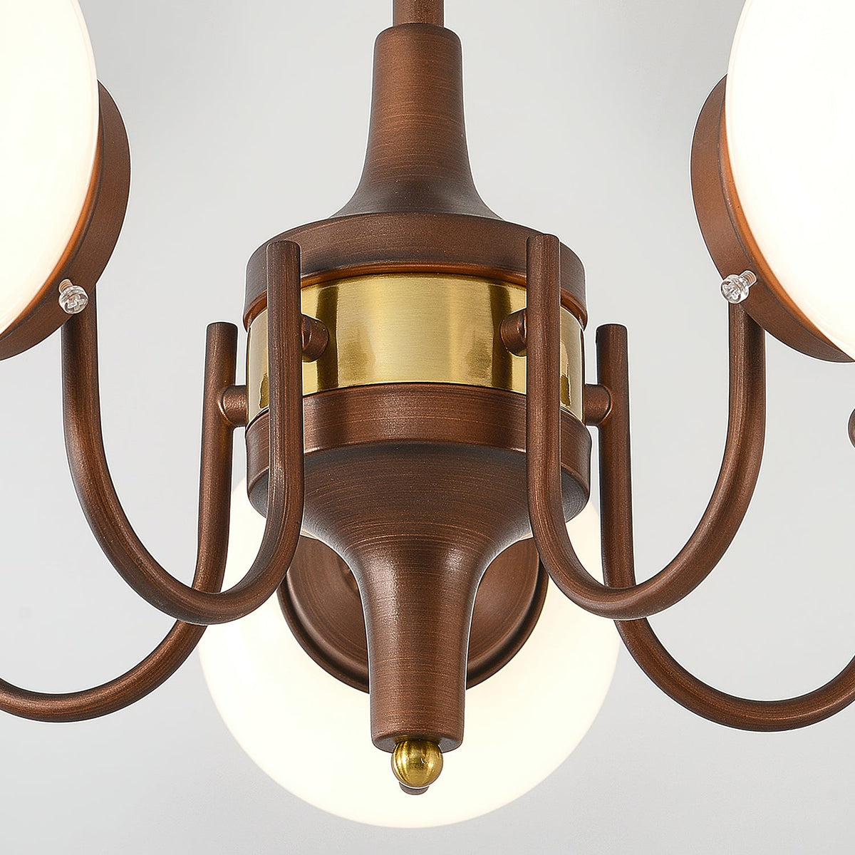 Close view of the central hub from below, with a brass band, arms and a small brass tip on this Clérachic chandelier.