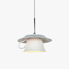 Clérachic pendant light lit, the glow through the shade in a quiet room.