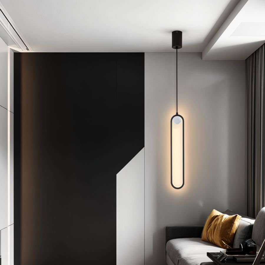 Clérachic black stadium-shaped LED pendant light glowing beside a dark feature wall and a grey sofa.