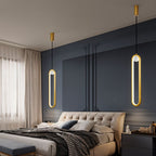 Clérachic pair of gold stadium-shaped LED pendants hung at different heights beside a bed against a navy panelled wall.