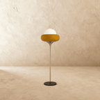 Clérachic floor lamp in yellow glass, shown side-on with its slim chrome stem and round black metal base.